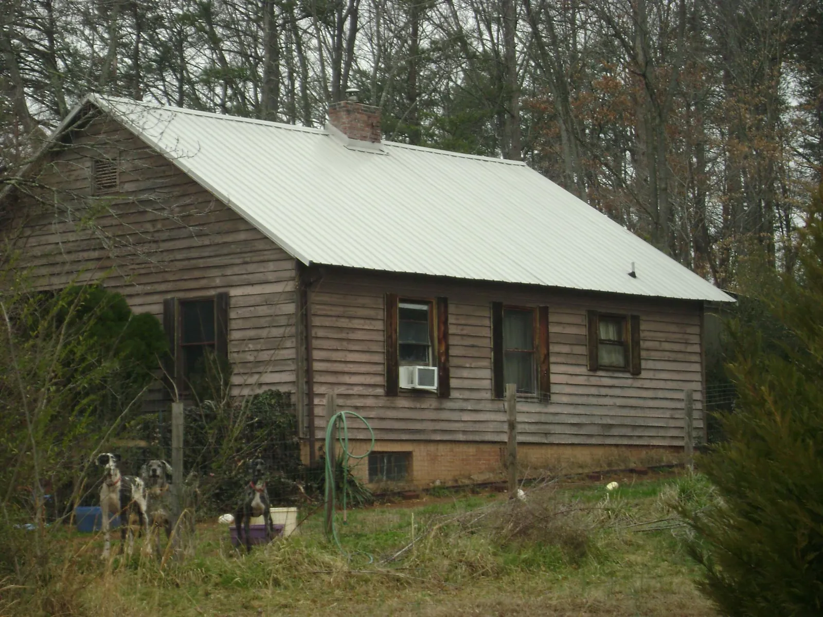 White metal roof on an old wood sided farmhouse, from a Metal Roof Installation job in Auburn